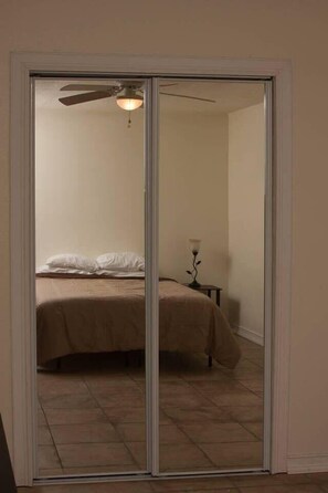 Relax in this serene bedroom with a comfortable bed and a convenient sliding door to the adjacent room.
