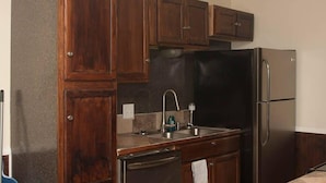Cozinha com armários de madeira escura, geladeira de aço inoxidável e lava-louças.