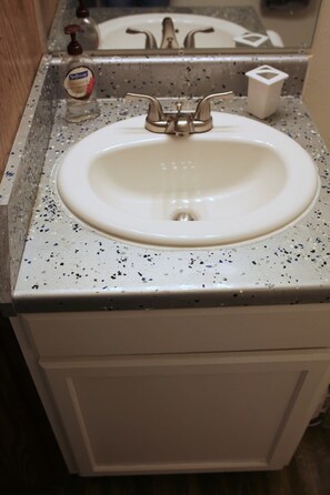 A bathroom sink with a speckled countertop and a mirror above it. - Relaxing Lawton Stay Close to Fort Sill (Lawton)