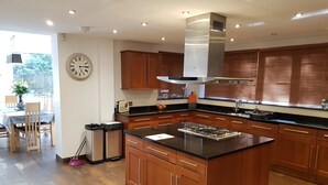 Een moderne keuken met houten kastjes, een centraal eiland en een ingebouwde kookplaat.