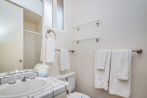 A bathroom with a sink, toilet, and towel racks.