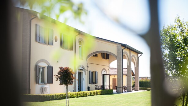 A large building with multiple arches and a well-maintained lawn. - Agriturismo Il Mondo (Parma)