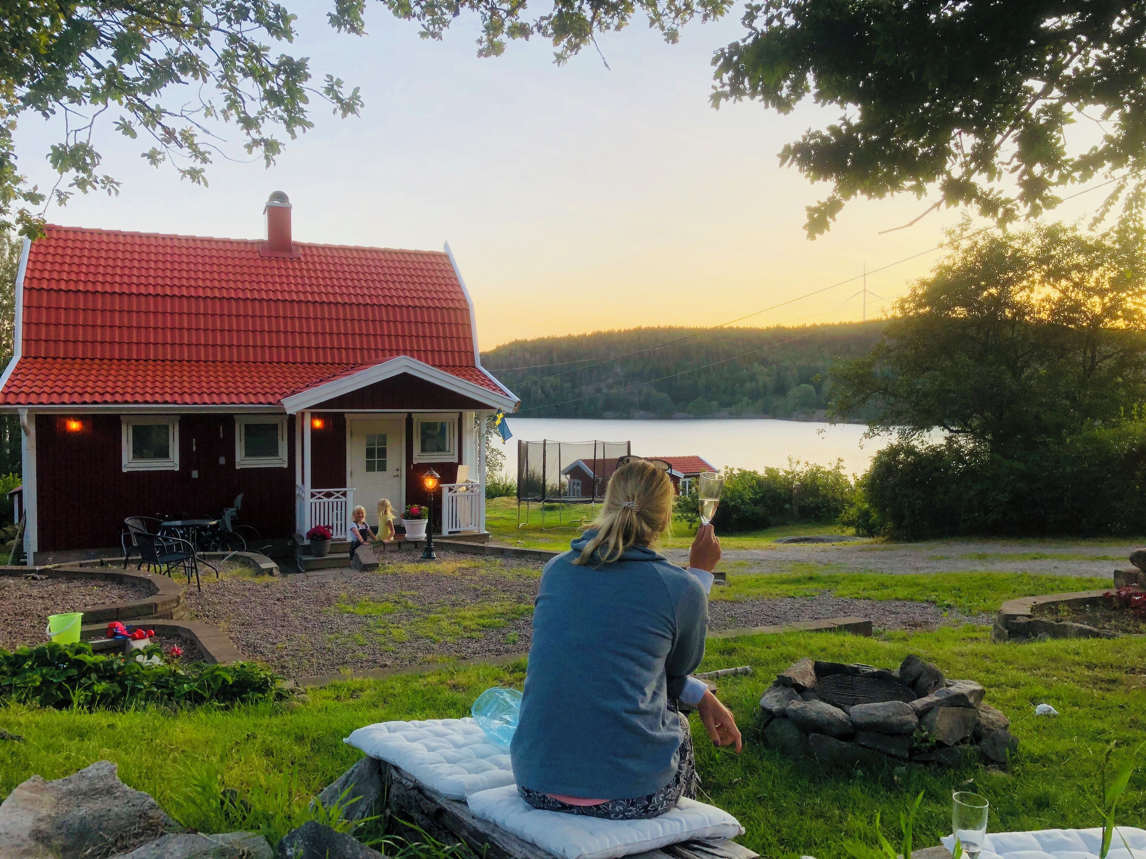 Ein Haus mit rotem Dach und einer Veranda mit Sitzgelegenheiten im Freien.