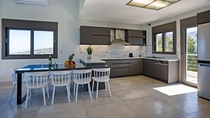 Una cocina moderna con comedor, ventanas amplias y vistas al exterior.