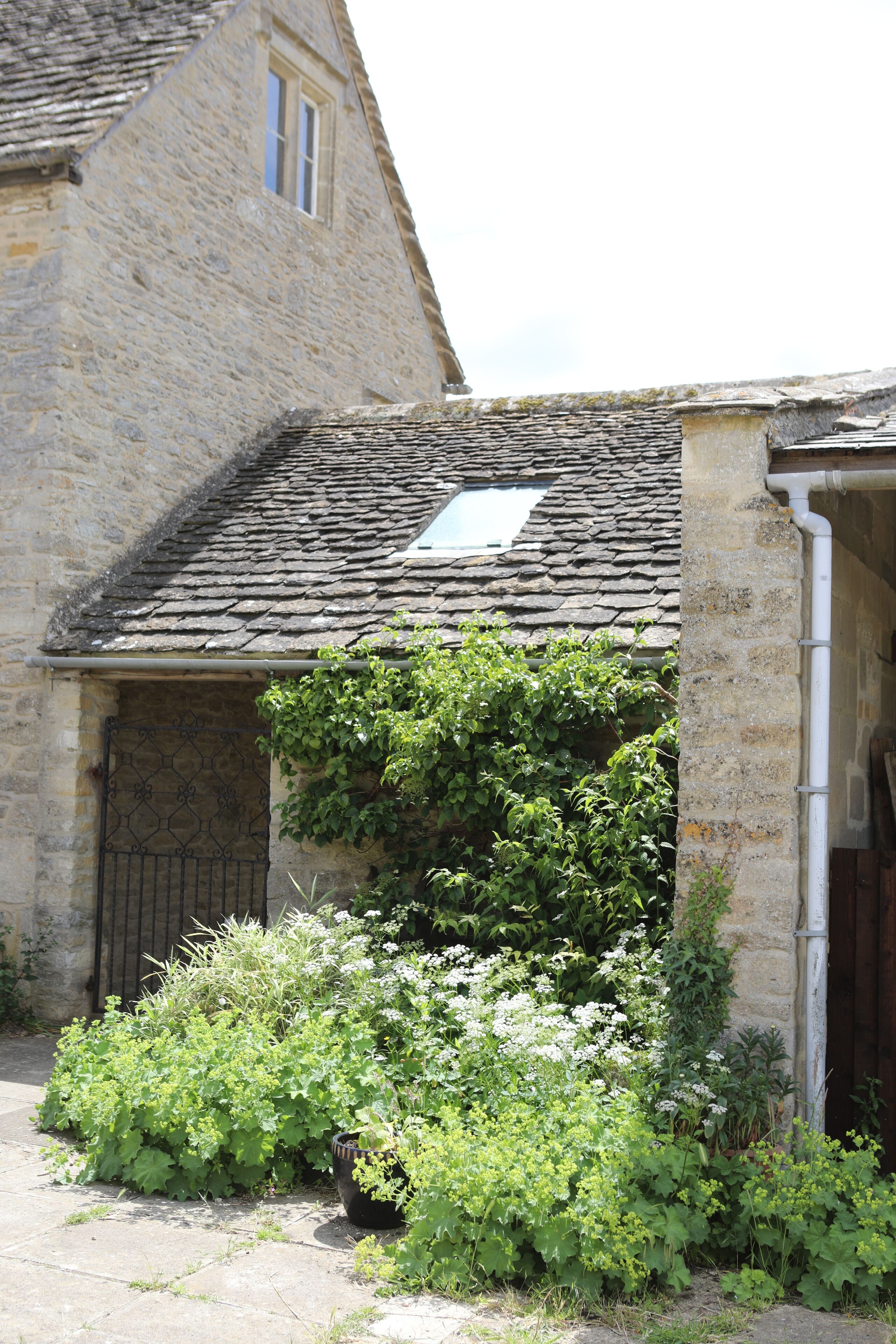 Un bâtiment en pierre avec un toit en pente et une petite fenêtre.