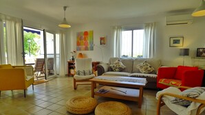 A living room with a sofa, armchairs, a coffee table, and a dining table. There are two woven baskets on the floor. - Sleeps 9 | Casa Vista Bella | CG R1248 (Nerja)