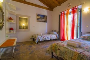 Une chambre avec deux lits, un bureau et une fenêtre avec des rideaux rouges.