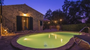 A swimming pool with lounge chairs and a stone building in the background. - Su La Strata house  by CorfuEscapes (Paxos)