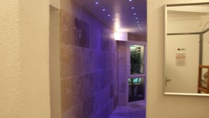 A hallway with tiled walls and a door with a sign. - Residence les jardins de Natallia (La Seyne-sur-Mer)