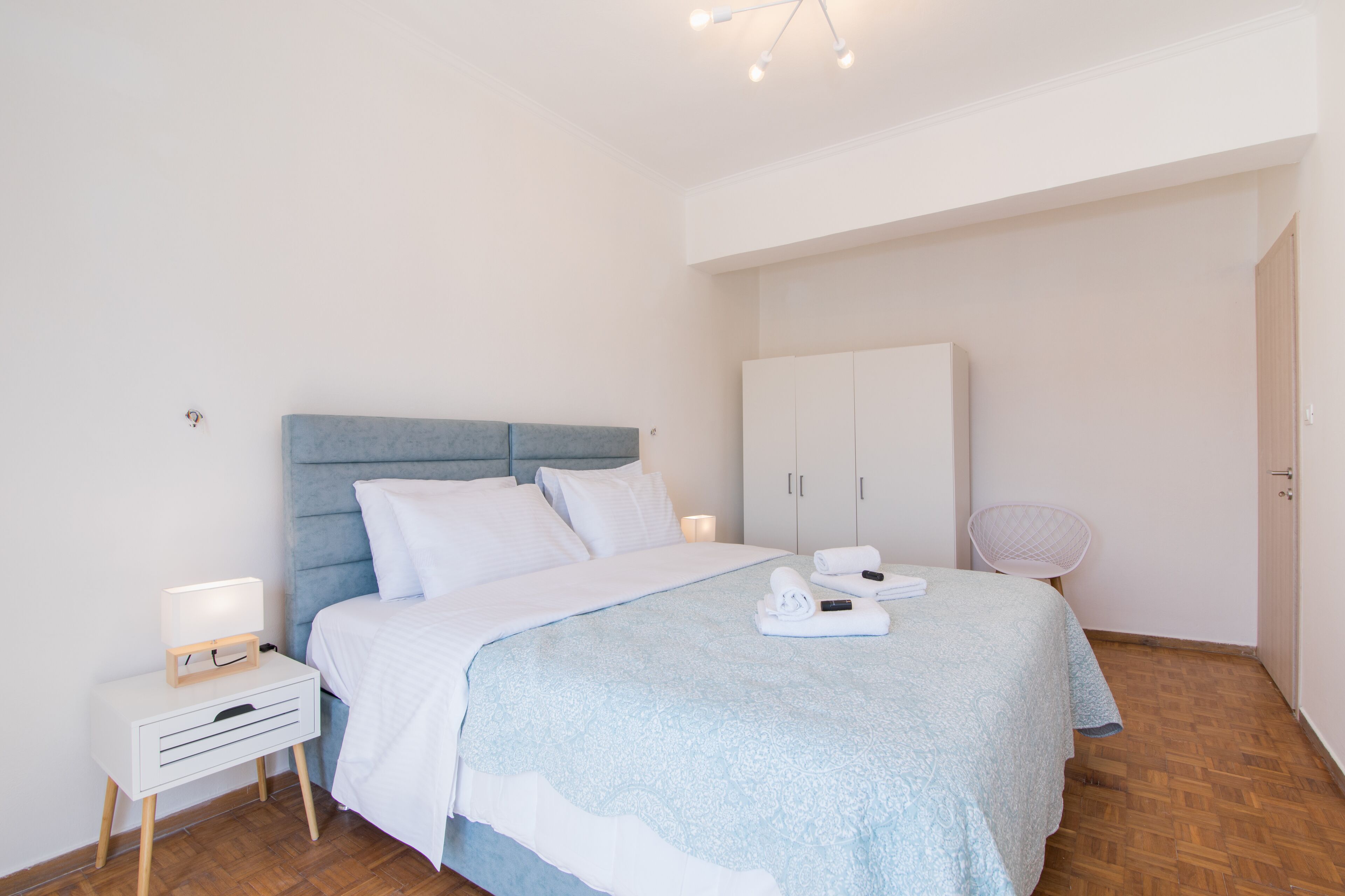 Un dormitorio ordenado con cama, mesita de noche y armario.