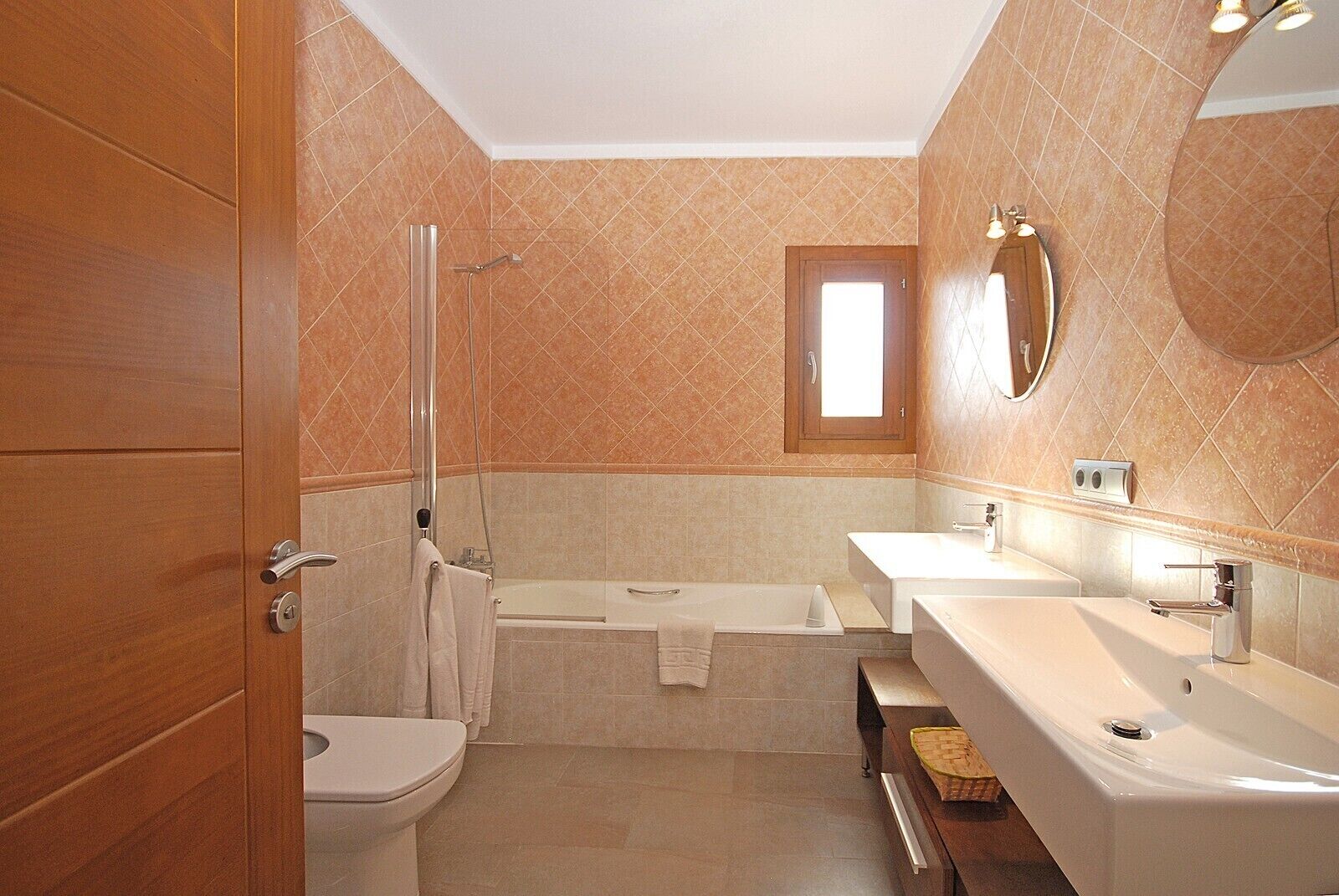 Ein Badezimmer mit Toilette, Dusche, Badewanne und zwei Waschbecken.