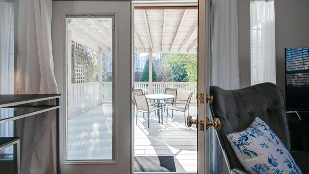 Una habitación con puerta de vidrio corrediza que da a un patio exterior con mesa y sillas.