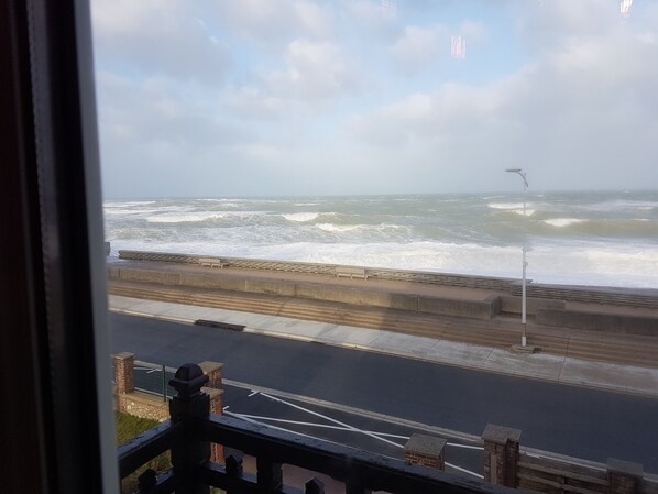 A view of the sea from a window, with waves crashing onto the shore. - "FACING THE SEA" VEULETTES SUR MER APARTMENT (Veulettes-sur-Mer)