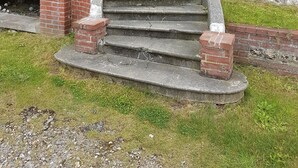 A staircase leading to a building with a stone facade and a brick exterior. - "FACING THE SEA" VEULETTES SUR MER APARTMENT (Veulettes-sur-Mer)
