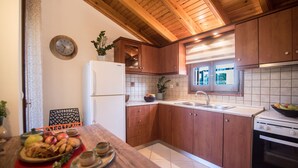 Eine Küche mit Holzausstattung, einem weißen Kühlschrank, einer Spüle und einem Herd.