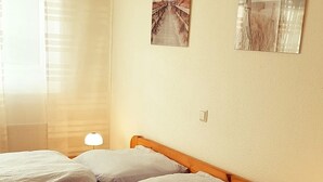 Ein Hotelzimmer mit einem hölzernen Bett, zwei Nachttischlampen und zwei gerahmten Bildern an der Wand.