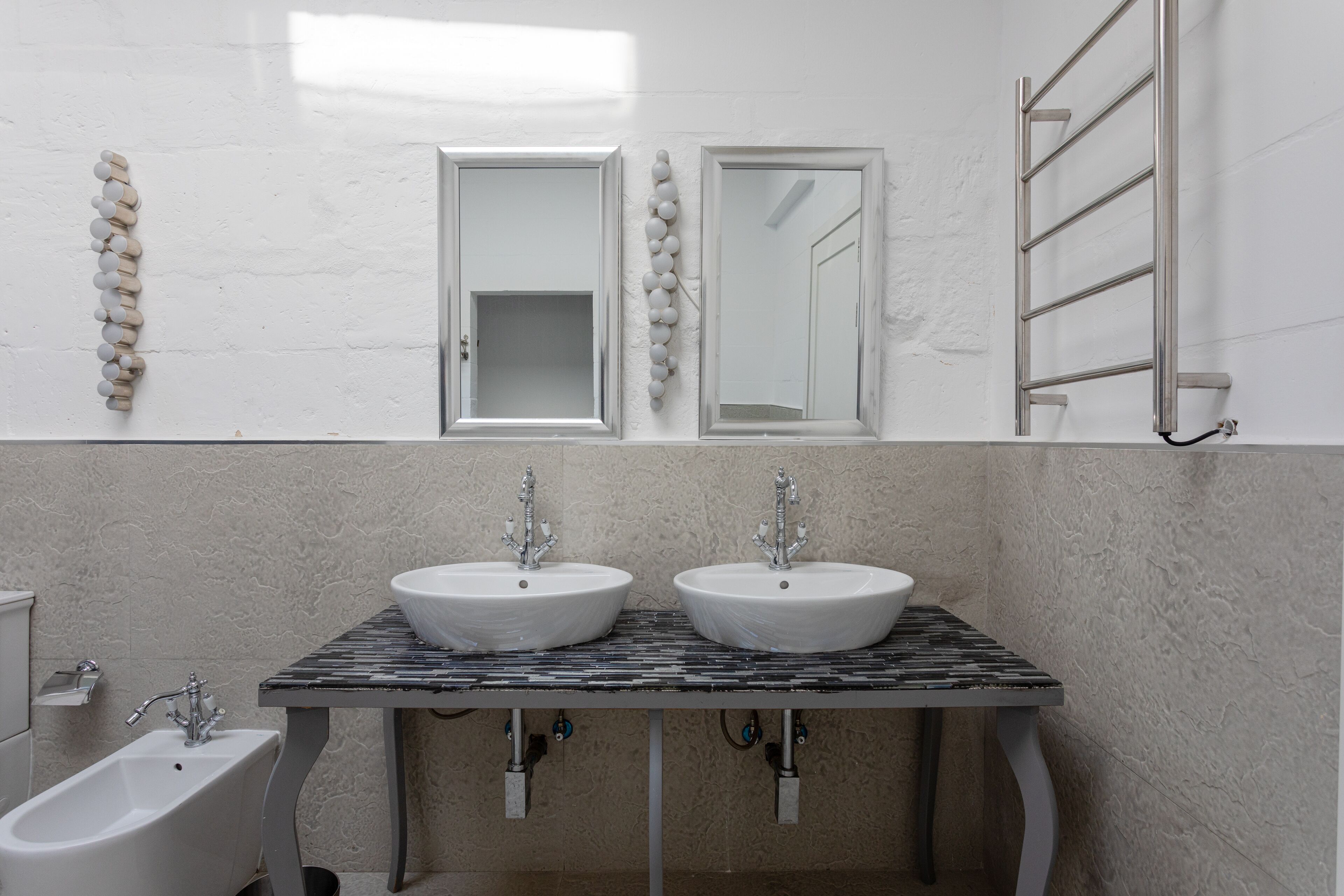 Ein Badezimmer mit zwei Waschbecken, einer Badewanne und einem Handtuchhalter.