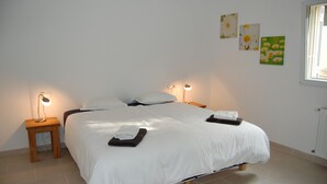 A neatly made bed with white linens, two bedside tables with lamps, and wall art. - Villa Vuelta , spacious house with private pool (Pals)