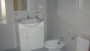 A bathroom with a sink, mirror, and toilet.