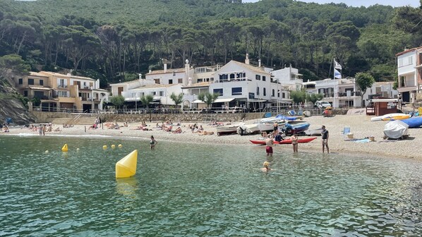 A coastal area with buildings, a beach, and boats.