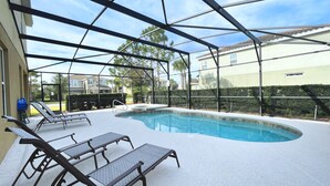 Une piscine extérieure couverte, dotée de chaises longues et d’un jacuzzi.
