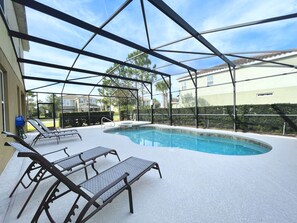 Une piscine extérieure couverte, dotée de chaises longues et d’un jacuzzi.