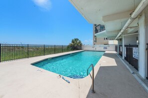 A swimming pool with a clear blue water, surrounded by a concrete deck and a metal railing. - Updated!!! Crescent Towers II 708,  2 BR Ocean Front Luxury Condo with Pool (North Myrtle Beach)