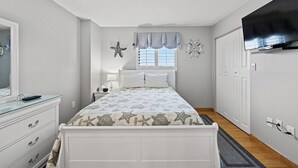 A bedroom with a bed, dresser, and a television. - Updated!!! Crescent Towers II 708,  2 BR Ocean Front Luxury Condo with Pool (North Myrtle Beach)