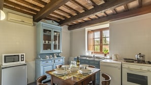 A kitchen with a wooden table set for dining, a blue cabinet, and white appliances.