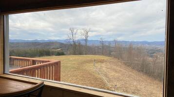 Eine Holzterrasse mit Blick auf eine hügelige Landschaft.