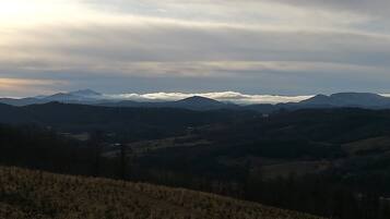 A panoramic view of a mountainous landscape with rolling hills and a valley.