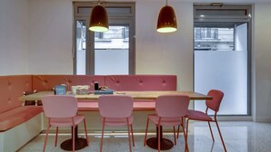 A modern dining area with a wooden table, pink chairs, and a pink sofa. - Sweett | Trevise - Three Bedroom Apartment, Sleeps 6 (Paris)