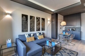 A modern living room with a sofa, coffee table, and artwork on the wall.