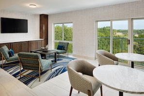 Een moderne woonkamer met een flatscreen televisie, een eettafel en twee banken.