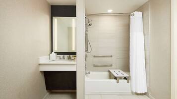 A modern bathroom with a bathtub, shower, and vanity.