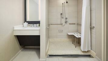 A modern bathroom with a shower, a sink, and a mirror.