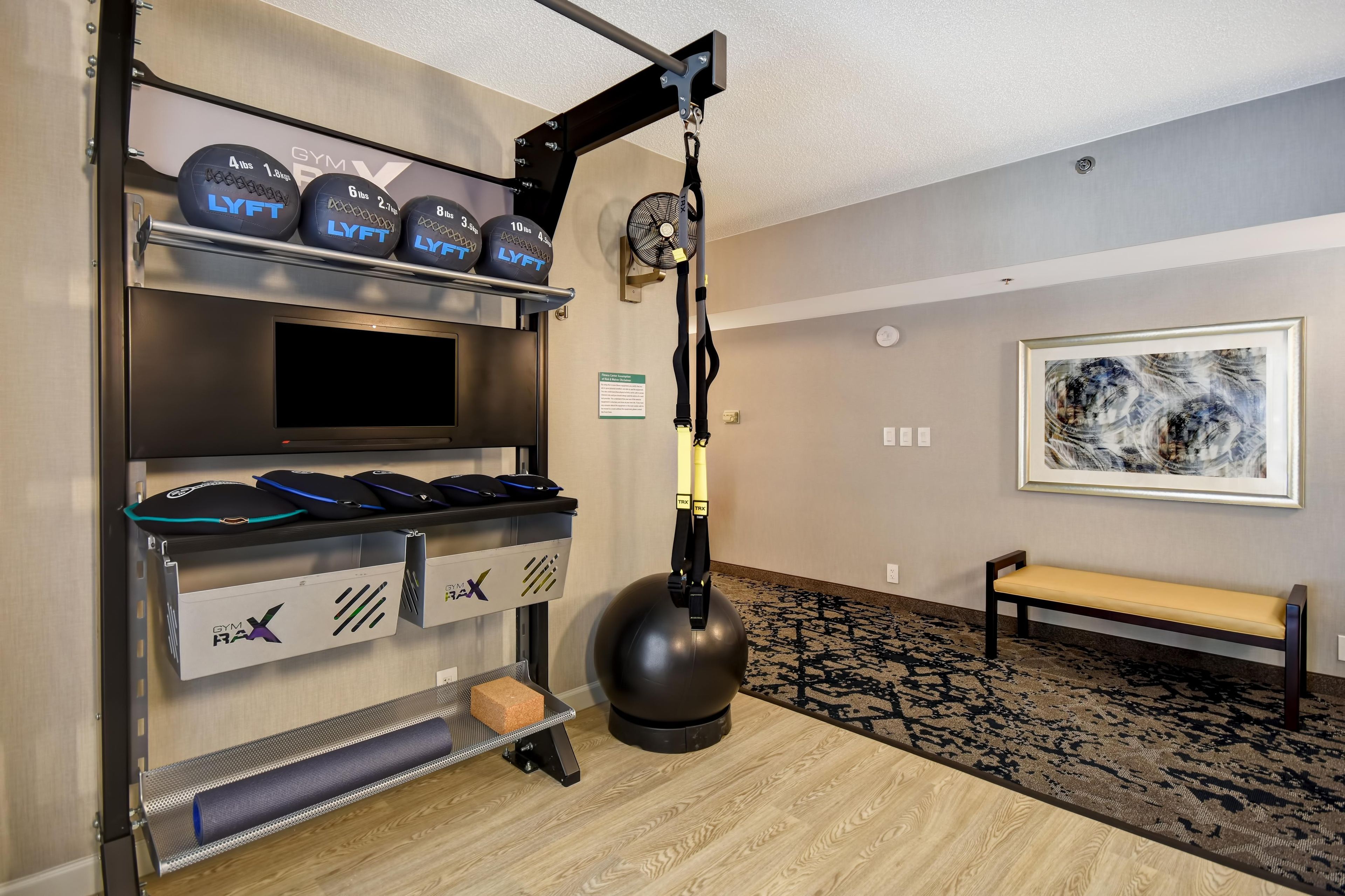 A gym with weightlifting equipment, a treadmill, and a bench.