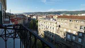 A cityscape with a view of buildings and a distant mountain range. - Al Garibaldino Rooms (Trieste)