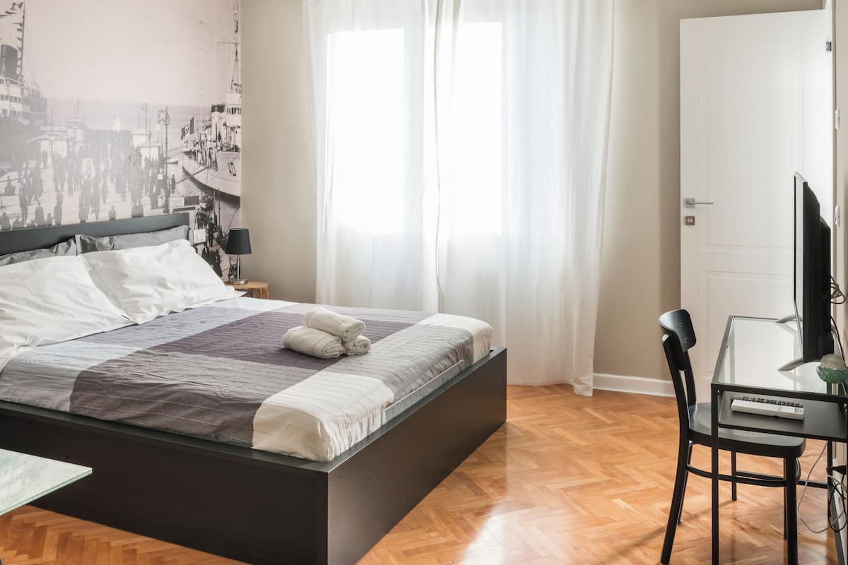 Quarto moderno com uma cama, uma escrivaninha e uma cadeira.