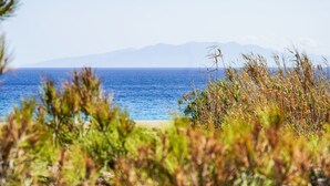 Un paisaje costero con vista despejada al mar y montañas a lo lejos.