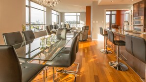 Ein moderner Konferenzraum mit Glastisch, Ledersesseln und Blick auf die Stadt.