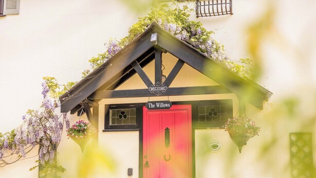 A building with a red door labeled 'The Willows.' - The Willows - Woodland Cottage with Log Burner (Christchurch)