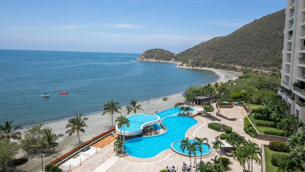 Un complexe hôtelier doté d’une grande piscine, d’une plage et offrant une vue sur les montagnes.