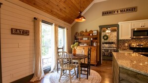 A kitchen with wooden cabinets, a granite countertop, and a hanging pendant light.