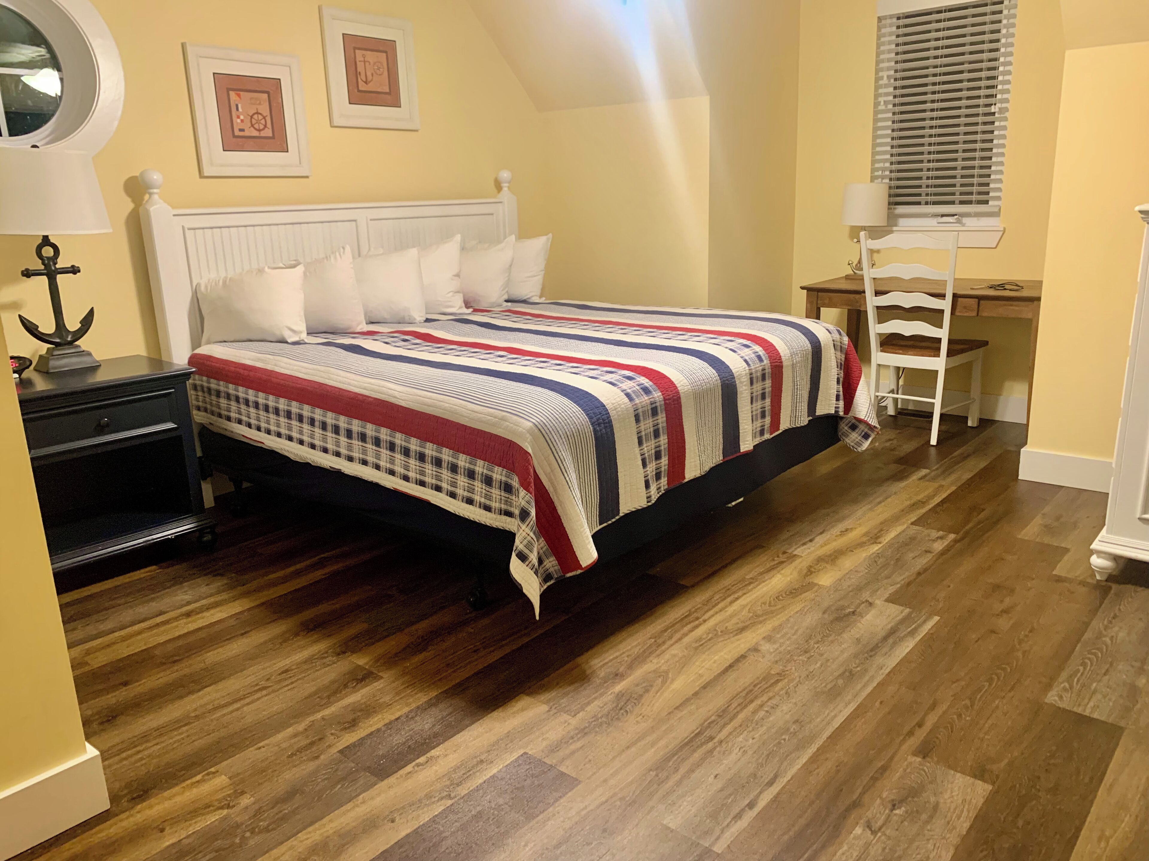 Une chambre à coucher avec un lit, une table de chevet, un bureau et une chaise.