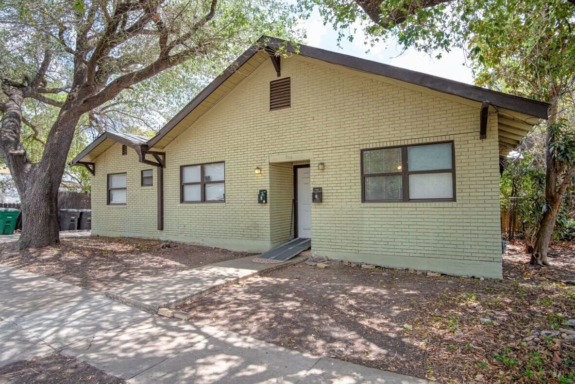 A single-story building with a gabled roof, a front door, and a small porch.