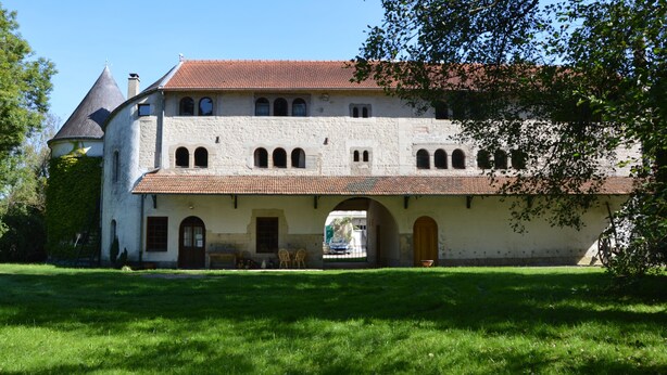 A historic building with a central courtyard, arched windows, and a tower. - Character cottage near Verdun (Dieue-sur-Meuse)