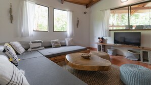 Un soggiorno moderno con un divano angolare grigio, un tavolino in legno e una televisione a schermo piatto.