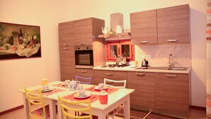 Une cuisine moderne avec des meubles en bois, une table à manger avec des chaises et un tableau accroché au mur.