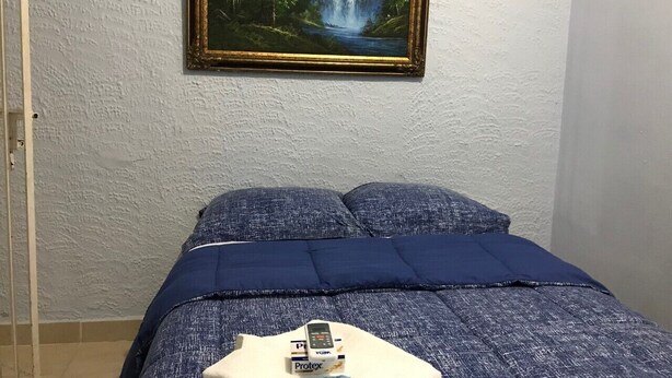 Ein Schlafzimmer mit einem Bett, einem Bild an der Wand und einer Tafel mit Schrift.
